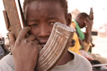 Kindersoldat der SLA im kurz zuvor zerstörten Ort Khor Abeche, Süd-Darfur, der von Dschandschawid-Milzen überfallen und in Brand gesteckt wurde, 11.05.2005